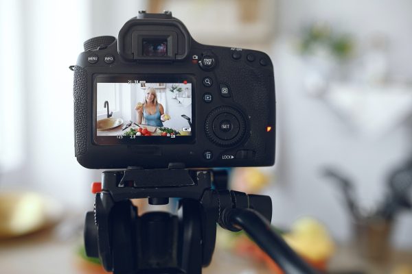 Beautiful and sporty girl in a kitchen recording a video